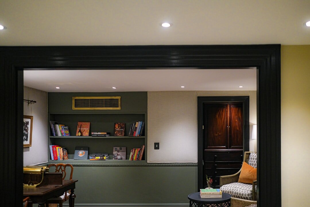 Bright home library and study with wooden shelves and armchair